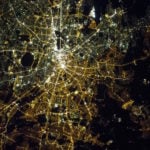 This photo shows the divide between East and West Berlin that is still visible at night from space. On the left are the gas lamps of the West and on the right, the orange high-pressure sodium lamps of the East, with a stark contrast between them. The image is a powerful reminder that lighting choices made by city planners are long lasting.