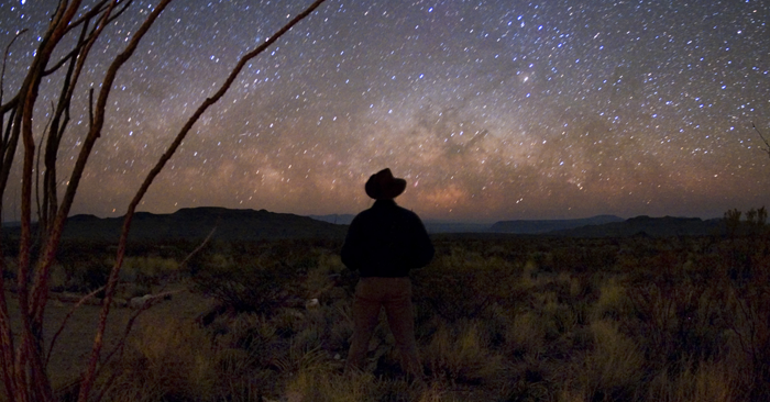 Man gazing up at the Milky Way at Big Bend National Park in Texas.