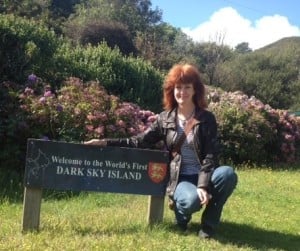 A picture of Ada next to the Isle of Sark sign. 
