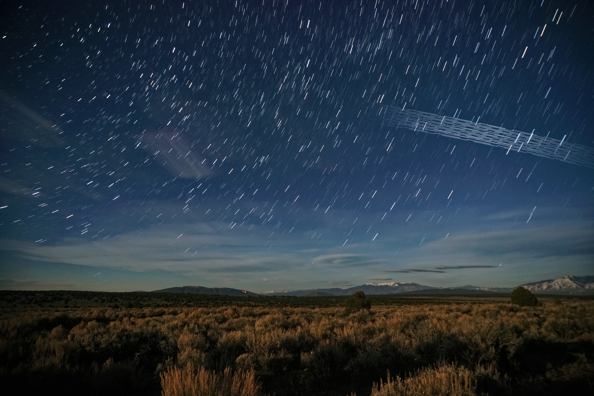 Starlink satellites streaking across a star filled sky. 