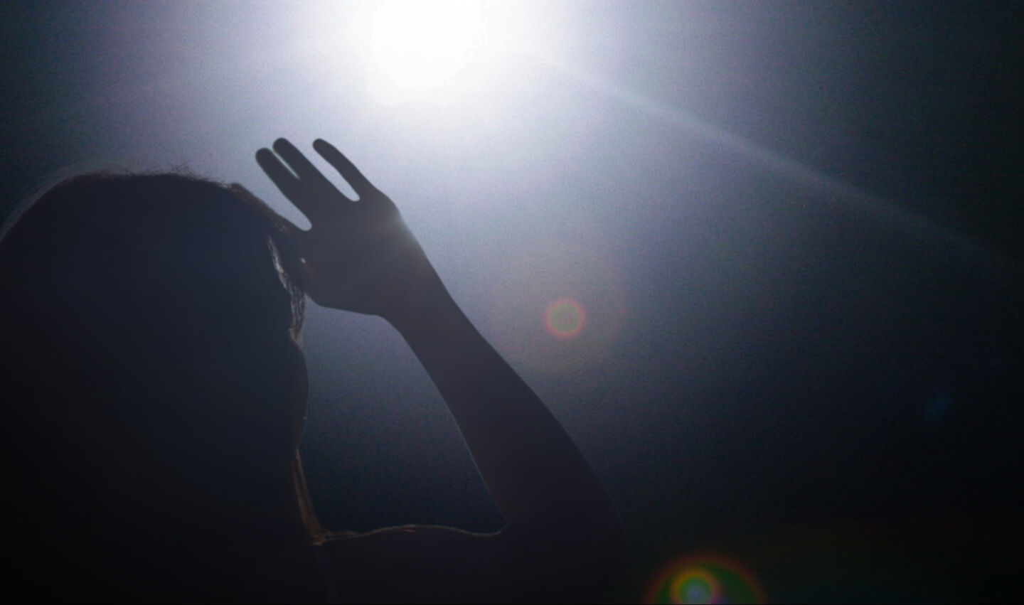 Woman blinded by glare from light at night.